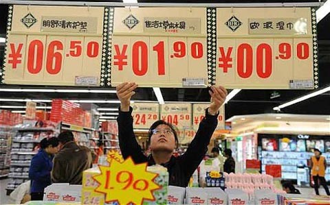 Người bán hàng trưng bảng giá mới tại một khu chợ ở vùng đông bắc Trung Quốc. Ảnh: AFP

