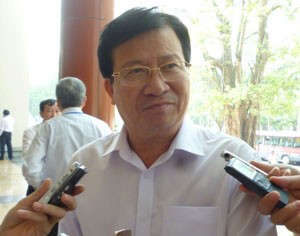 Bộ trưởng Trịnh Đình Dũng trả lời về sự cố vỡ đập thủy điện Ia Krel 2 bên hành lang Quốc hội - Ảnh: Bùi Trang